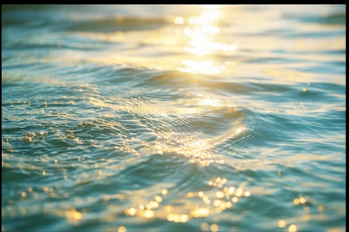 Sunlit water surface catching golden light, teal and amber tones
